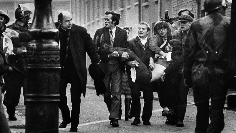 Bishop Daly helps clear a path for a man badly injured during Bloody Sunday in Derry.