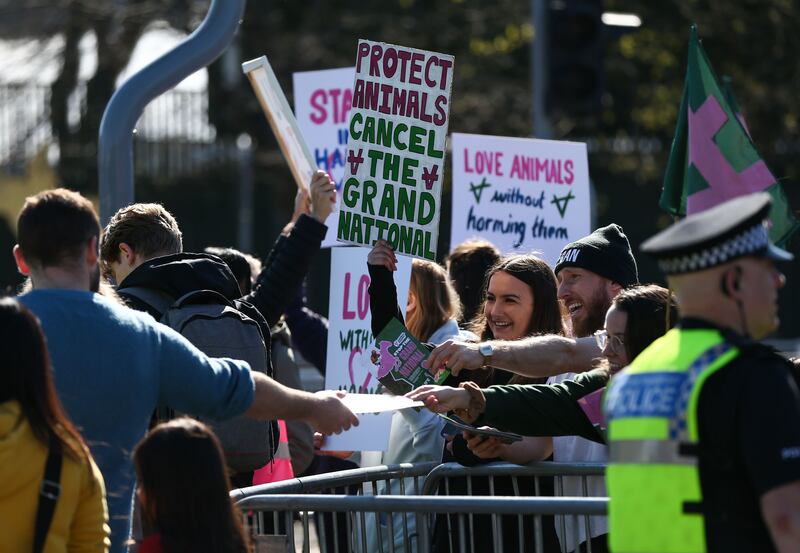 People walk past animal rights protesters handing out leaflets about their cause outside Aintree Racecourse ahead of the 2023 Grand National at Aintree Racecourse in Liverpool. Photograph: Adam Vaughan/EPA