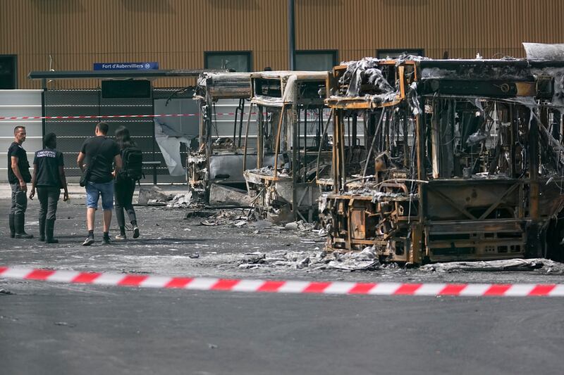 Police investigators examine charred buses after a third night of unrest at a depot in Aubervilliers near Paris. Photograph: Michel Euler/AP