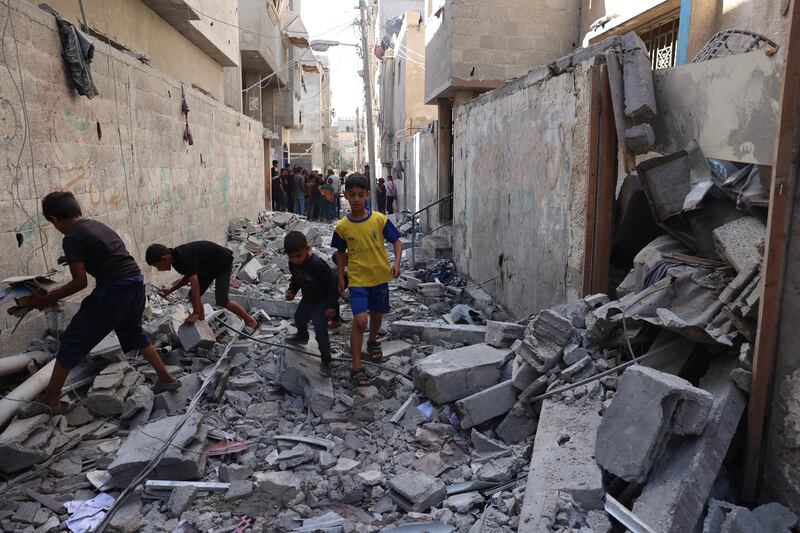 Palestinian children walk through rubble following an Israeli bombardment of Rafah's Tal al-Sultan district. Photograph: AFP
