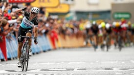 Tony Martin survives treacherous cobblestones to take yellow jersey
