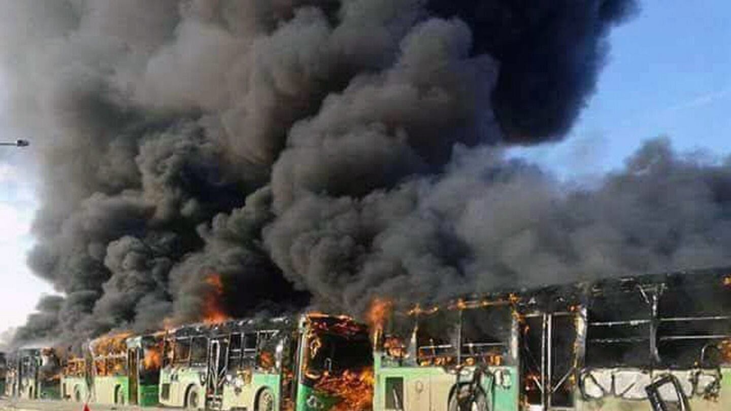Smoke rising from green government buses in Idlib province, Syria on Sunday. Activists said militants had burned at least five buses assigned to evacuate wounded and sick people from two villages in northern Syria. Photograph: SANA via AP