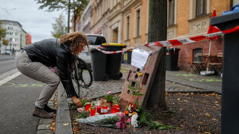 A woman lays flowers  in front of the doner kebab restaurant that was one of the sites of a shooting in Halle on Wednesday. Photograph:  Axel Schmidt/AFP via Getty Images