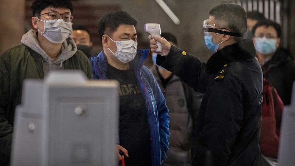A passenger who arrived on the last bullet train from Wuhan to Beijing is checked for a fever by a health worker on Thursday. Photograph: Kevin Frayer/Getty Images