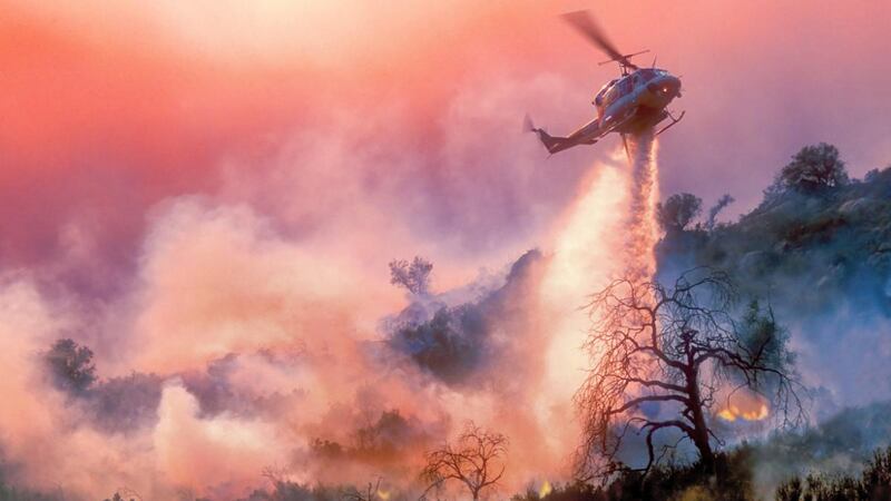 A helicopter dropping water on a wildfire in Calafornia, USA, in 2020. Photograph: iStock