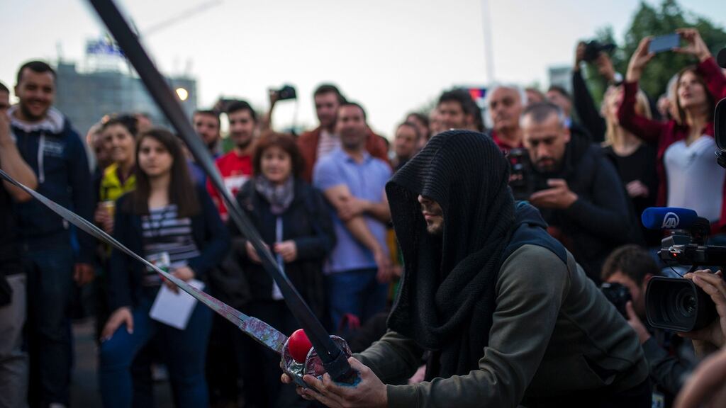 A protester uses an improvised slingshot to throw paint-filled balloons towards the parliament building during an anti-government protest in Skopje. Photograph: Robert Atanasovski/AFP/Getty Images