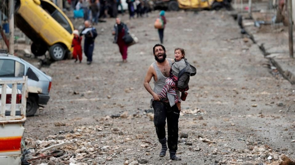 A man flees an Islamic State-controlled part of Mosul with his daughter, towards Iraqi special forces soldiers during a battle in the Iraqi city. Photograph: Goran Tomasevic/Reuters