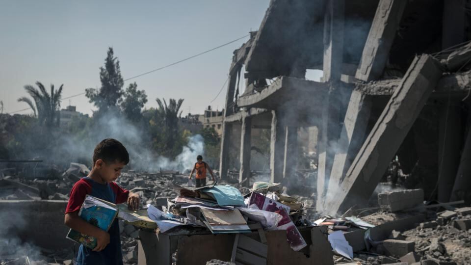 Palestinian children gather books from the rubble of the Imam Shafi’i Mosque in Gaza city. Photograph: Sergey Ponomarev/The New York Times