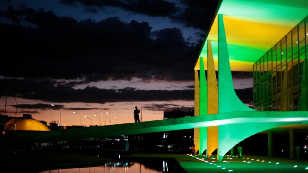 A security guard walks in front of the Planalto Palace In Brasilia as it is lit up in the colours of the Brazilian national flag ahead of the World Cup. Photograph: Ueslei Marcelino/Reuters
