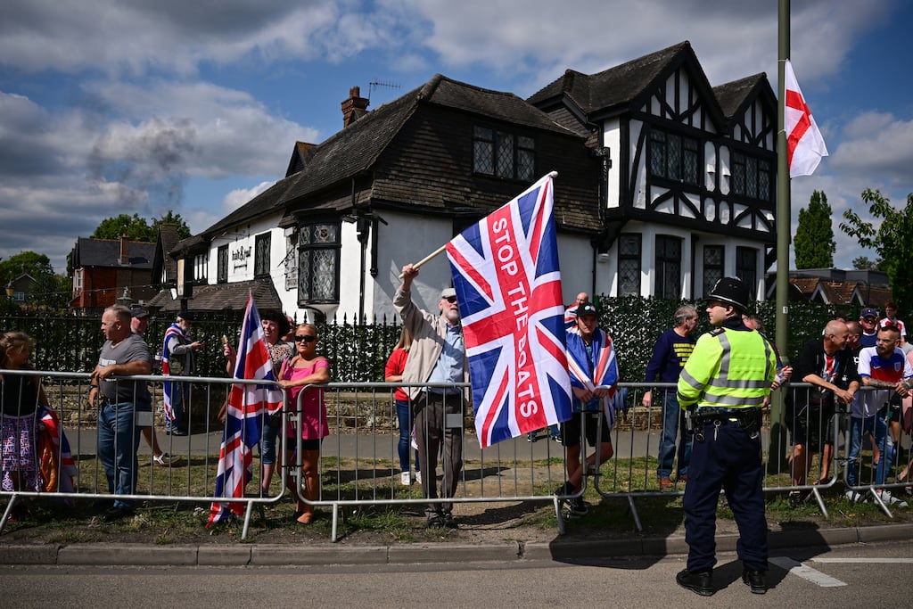 A protestor holds a Union Flag reading 'Stop The Boats' during an anti-immigration rally outside the Sheraton Four Points hotel, believed to be housing asylum seekers, in Horley, south of London, on August 23rd, 2025. Photograph: Ben Stansall/AFP via Getty Images