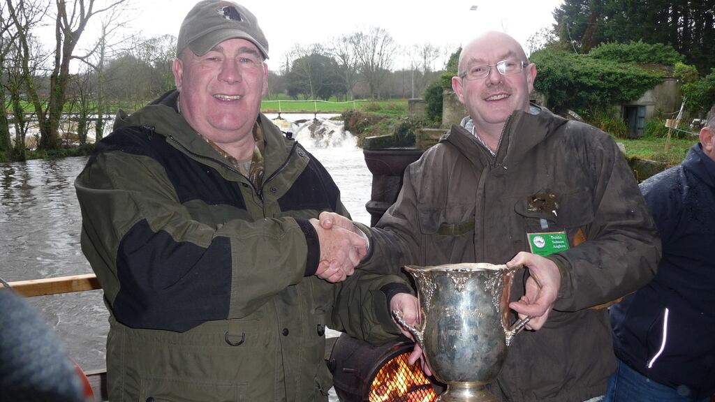 Dublin Salmon and Sea Trout Anglers committee member Declan Briggs (left), presenting the Liffey Cup to clubman of the year, Colm Adams, at Islandbridge on the Liffey on New Year’s Day.