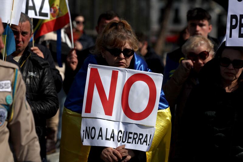A demonstrator wrapped in the Ukrainian flag holds a sign reading 'No to the war' during a protest to mark one year since Russia's invasion of Ukraine, in Madrid, on Sunday. Photograph: Pierre-Philippe Marcou/AFP/Getty