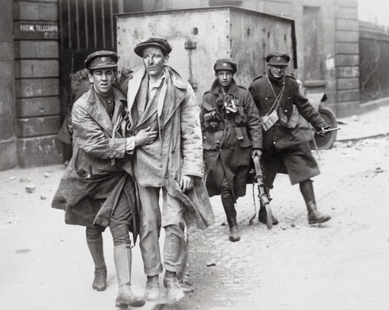 One of the wounded rebels is brought out of the smoking and burning Four Courts building after the surrender to the Free State troops. Photograph: Getty Images