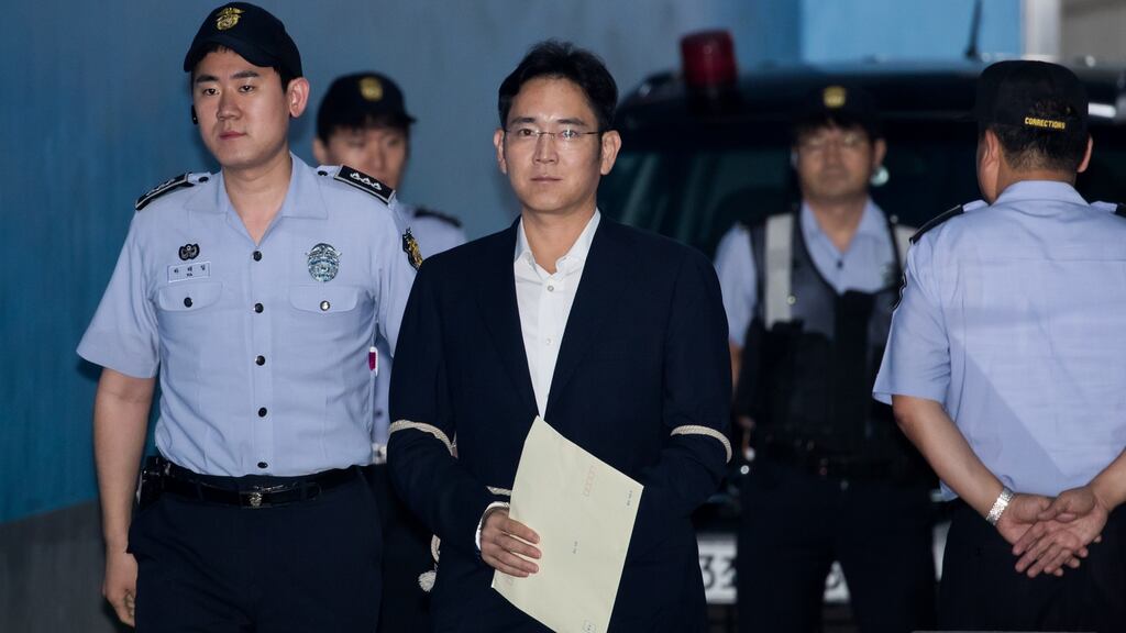 Jay Y Lee, co-vice chairman of Samsung Electronics, center, is escorted by a prison officer as he arrives at the Seoul Central District Court in Seoul, South Korea, on Monday. (Photograph: SeongJoon Cho/Bloomberg)