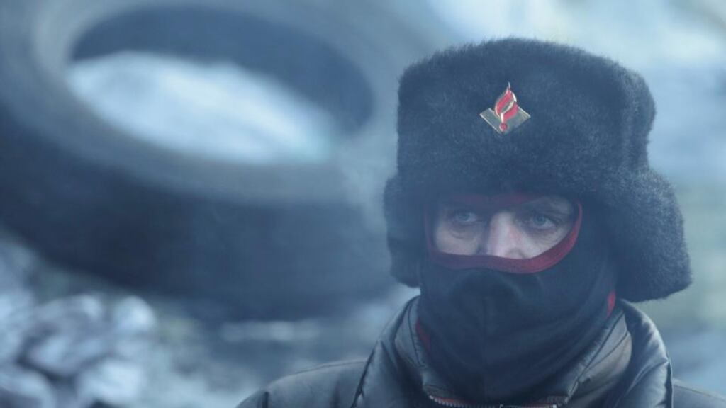 A demonstrator looks on at a barricade erected by anti-government protesters at the site of clashes with riot police in Kievtoday. Photograph: Konstantin Chernichkin/Reuters