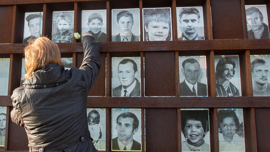 A woman places a rose by a photograph of Cengaver Katranci (8) on a memorial to victims of the Berlin Wall