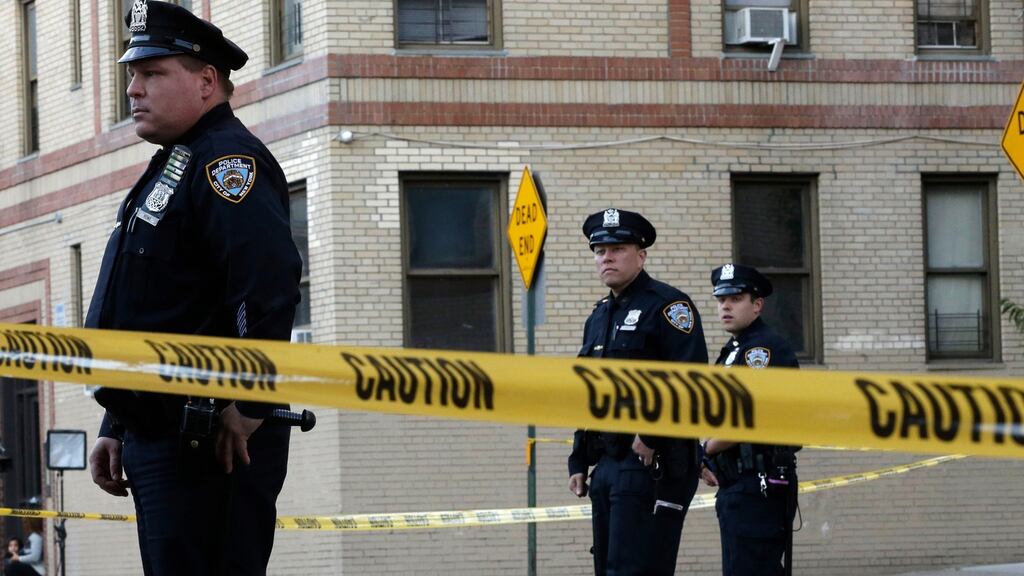 Police officers stand guard near an apartment building in the Bronx borough of New York where a six-month-old girl died on Thursday after being thrown from a window. Photograph: Mary Altaffer/AP Photo