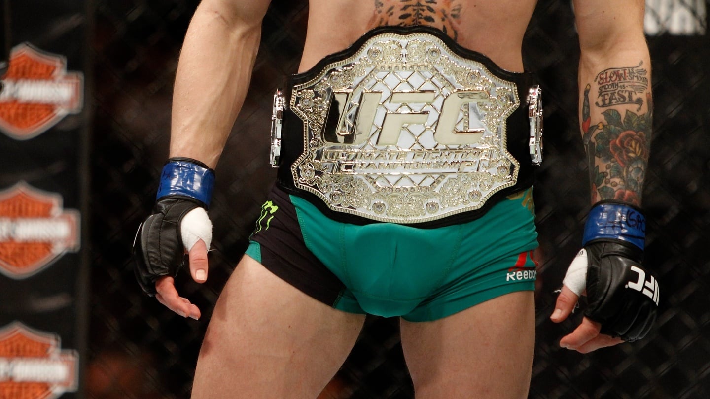 Conor McGregor wears the championship belt after a first-round knockout victory over Jose Aldo. Photograph: Getty