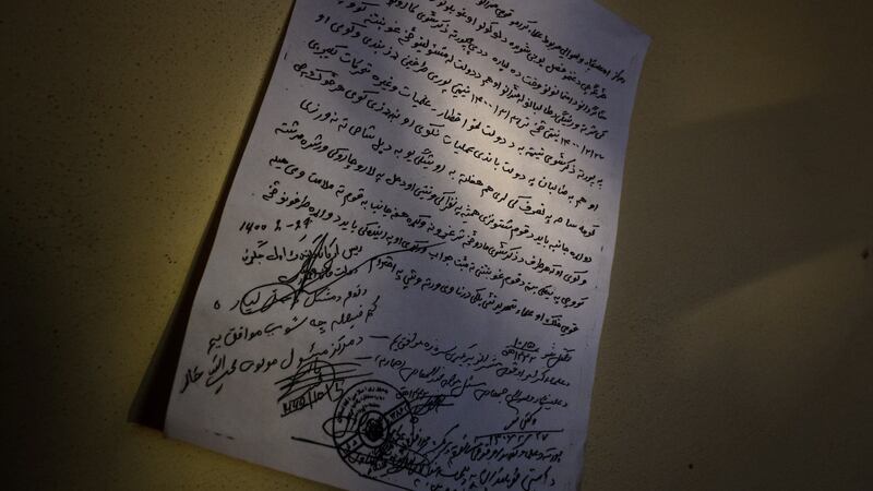A handwritten note, signed by Taliban and Afghan government officials, outlining a ceasefire in Mehtar Lam, Afghanistan. Photograph: Jim Huylebroek/The New York Times