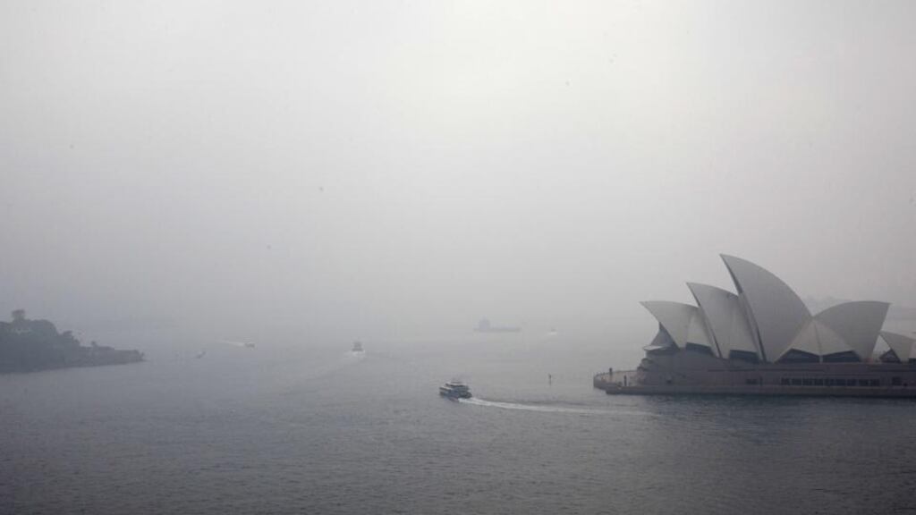 People look on as a fire smoulders at Voyager Point in western Sydney on January 5th. Photograph: Jenny Evans/Getty