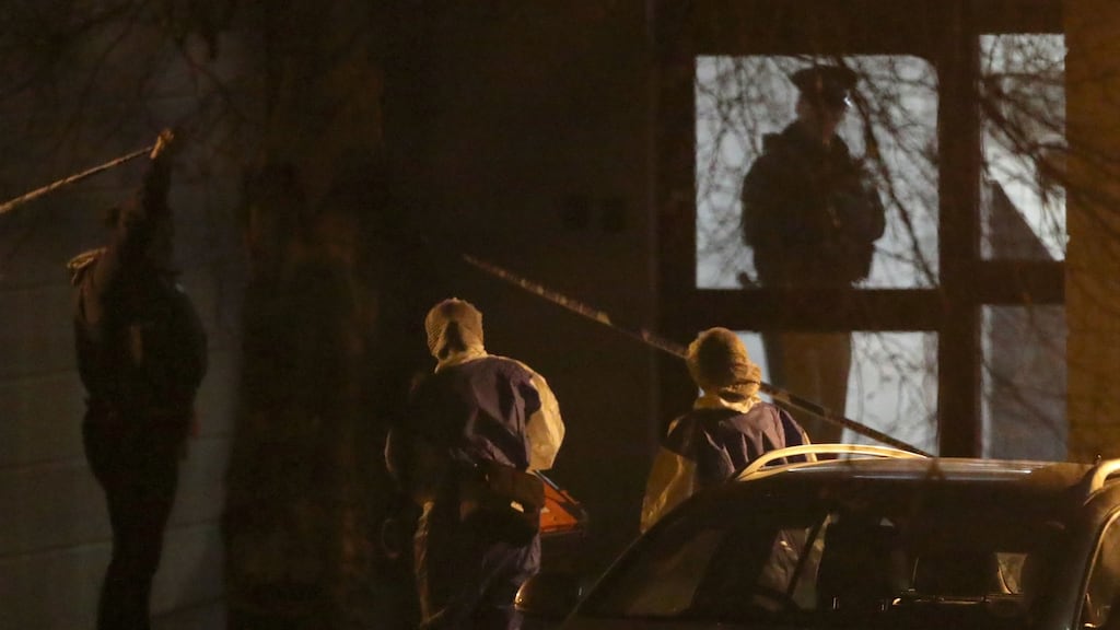 A PSNI officers lifts the cordon tape for PSNI forensic officers as they enter a building on Kinnaird Close in Belfast, after the bodies of a man and a woman were found in an apartment on Monday afternoon. Photograph : Liam McBurney/PA Wire