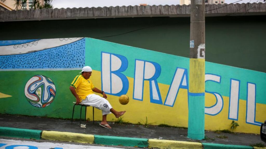 Brazilian Alvaro Diniz plays with a football in a street adorned with World Cup themed designs in São Paulo, Brazil, this week. The World Cup will begin on Thursday. Photograph Diego Azubel/EPA