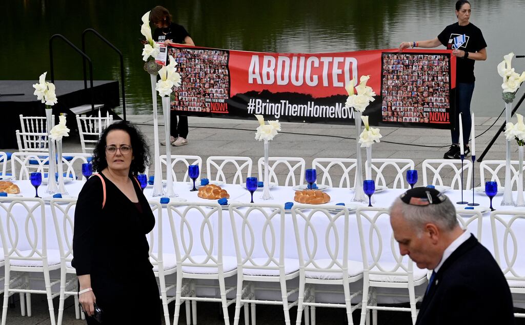 People walk by as a Shabbat Dinner table is prepared with 200 empty seats representing the Israeli hostages and missing people, at the Lincoln Memorial in Washington, DC, on Friday. Photoraph: Olivier Douliery/AFP