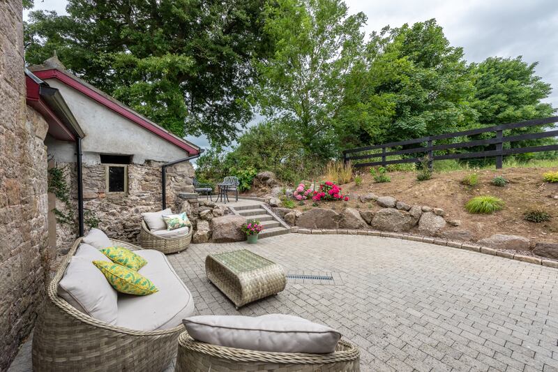 A sheltered patio lies to the rear