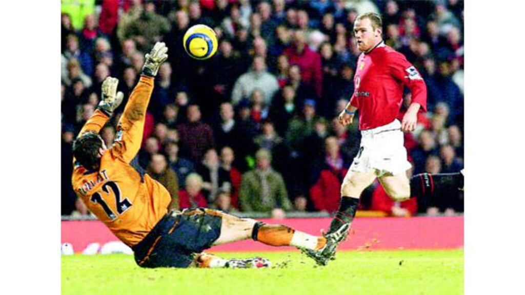 Wayne Rooney chips Wigan Athletic goalkeeper Matt Pollitt to score Manchester United's third - and his second - goal during their Premiership tie at Old Trafford last night.