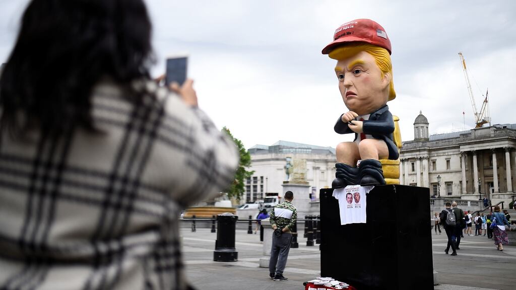 A demonstrator takes a picture of Donald Trump statue, during a protest in Trafalgar Square, London. Photograph: Clodagh Kilcoyne/Reuters