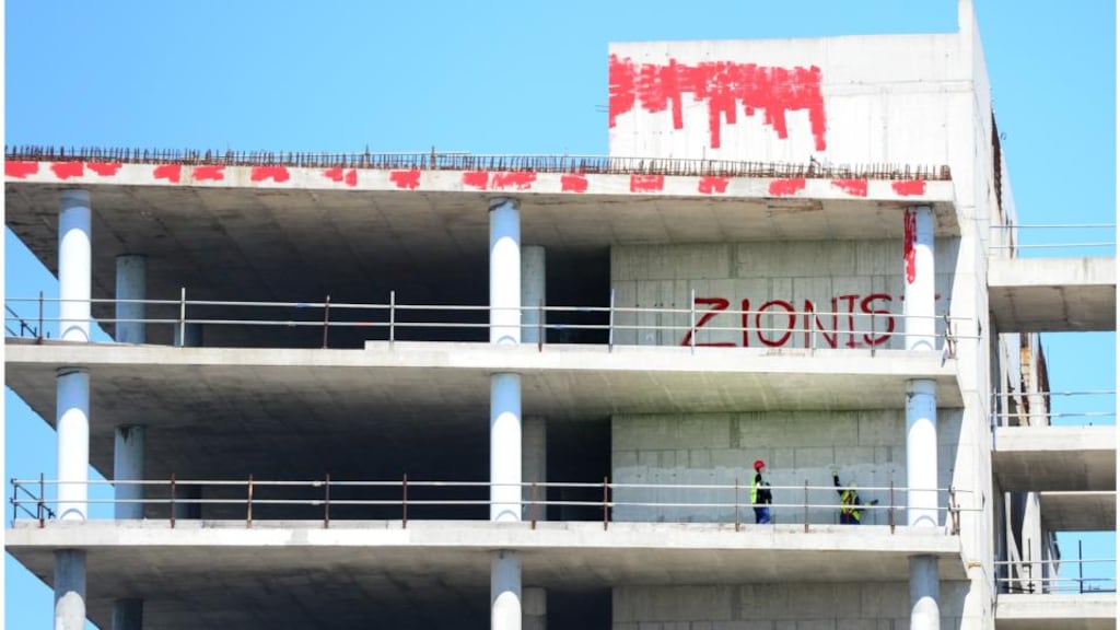 Workers paint over graffiti with red paint on the shell of the former Anglo Irish building on the North Quay Dublin near the IFSC. The building was sold by NAMA to the Central bank in 2012. Photograph: Bryan O’Brien/The Irish Times