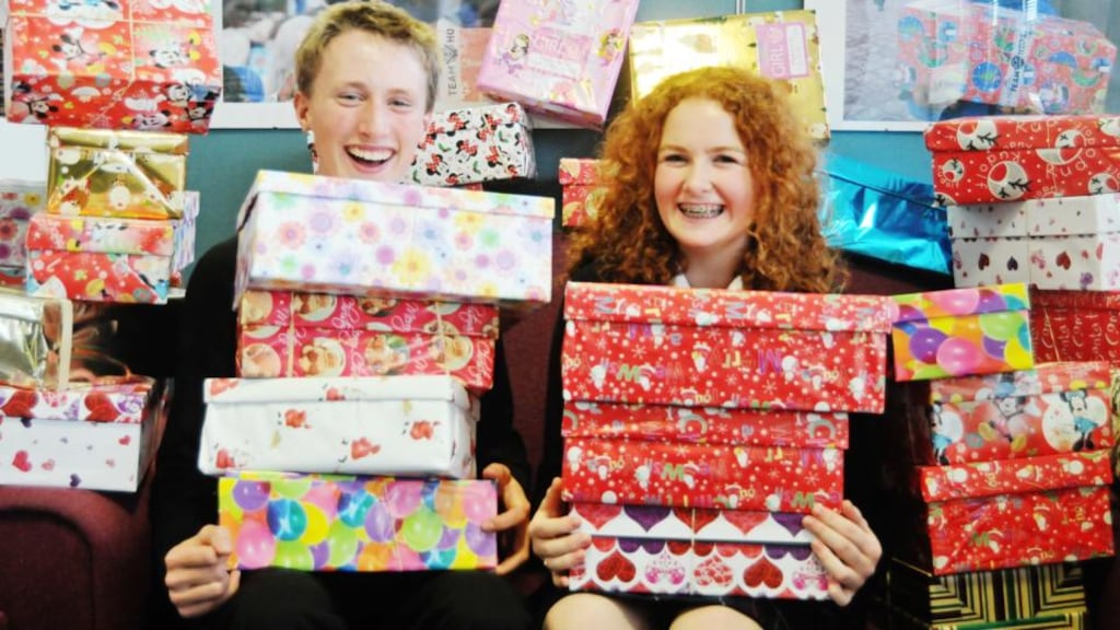 Christmas box: Jack Scollard and Amy Logan of  High School, Rathgar, with some of the boxes they and their schoolmates wrapped and filled for Team Hope. Photograph: Krista Burns