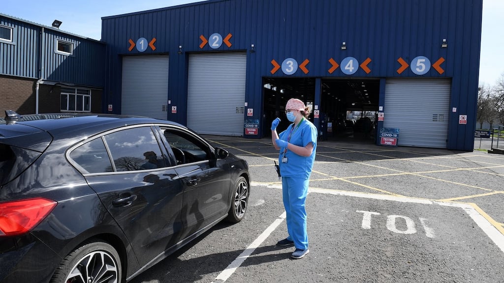 Medical staff direct cars at an MOT testing centre in Belfast which is being used as a drive through testing location for Covid-19. Photograph: Justin Kernoghan/PA Wire.