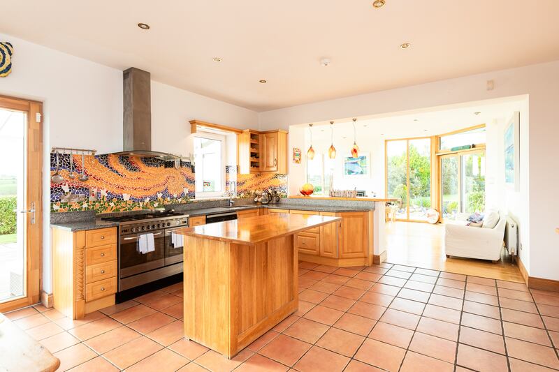 Kitchen featuring mosaic tiled splash back and Maltese glass light fittings