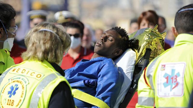 A man is helped as he disembarks from a Coast Guard boat in the Sicilian harbour of Palermo on Sunday. The death toll from Sunday’s shipwreck off the coast of Libya was uncertain after officials said there had been at least 700 people on board, some reportedly locked in the hold. Photograph: Guglielmo Mangiapane/Reuters