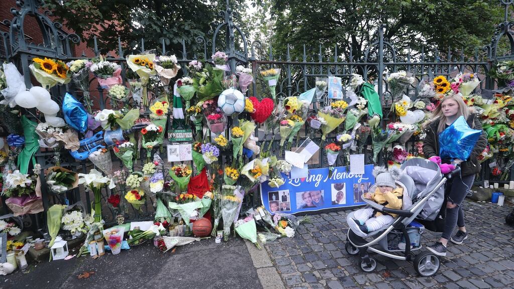 A woman passes floral tributes to Noah Donohoe at St Malach’s College where he went to school in Belfast. Photograph: PA