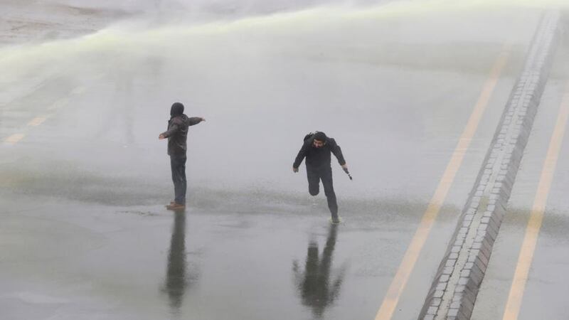Demonstrators marching along a main highway to protest the death of Berkin Elvan react as riot police fire water cannons to disperse them. Photograph: Umit Bektas/Reuters