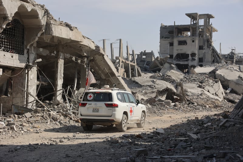 A Red Cross vehicle drives past destroyed building as the search for the bodies of Israeli hostages resumes in Gaza City. Photograph: Omar Al-Qattaa/AFP via Getty Images