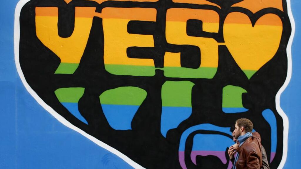 Men walk past a Yes vote campaign graffiti in central Dublin. Photograph: Darren Staples/Reuters