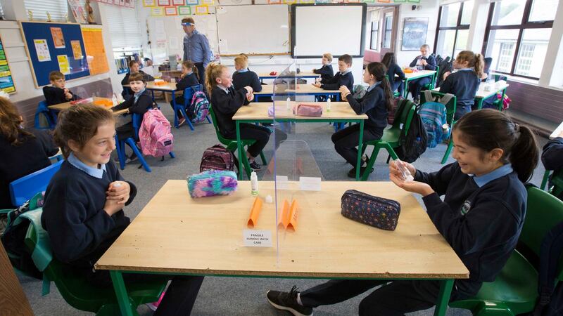 Mona Lowe (right) uses her bottle of hand sanitsier in class. Photograph: Brian Farrell/The Irish Times