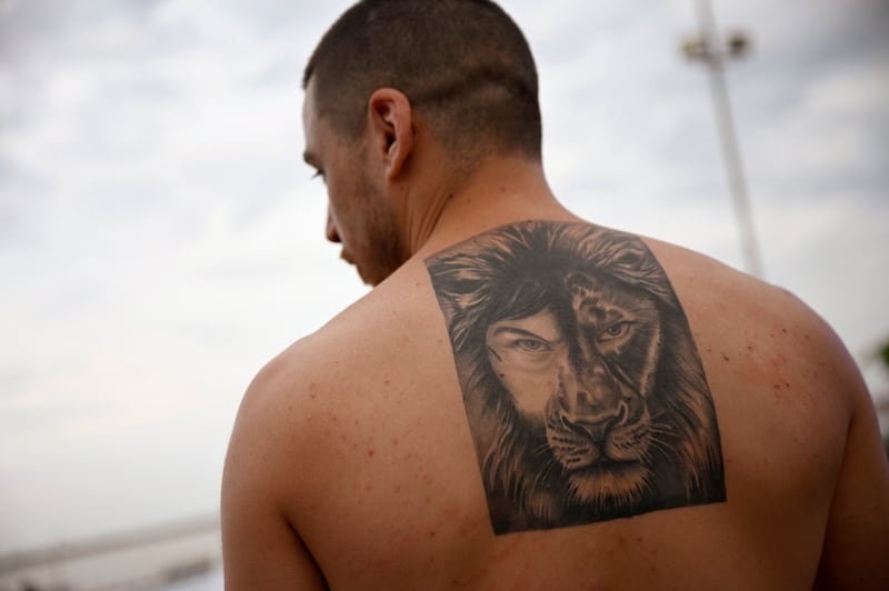 Edgar Morra shows his Milei-Lion tattoo at an LLA campaign rally in Rosario. Photograph: Luis Robayo/AFP via Getty Images