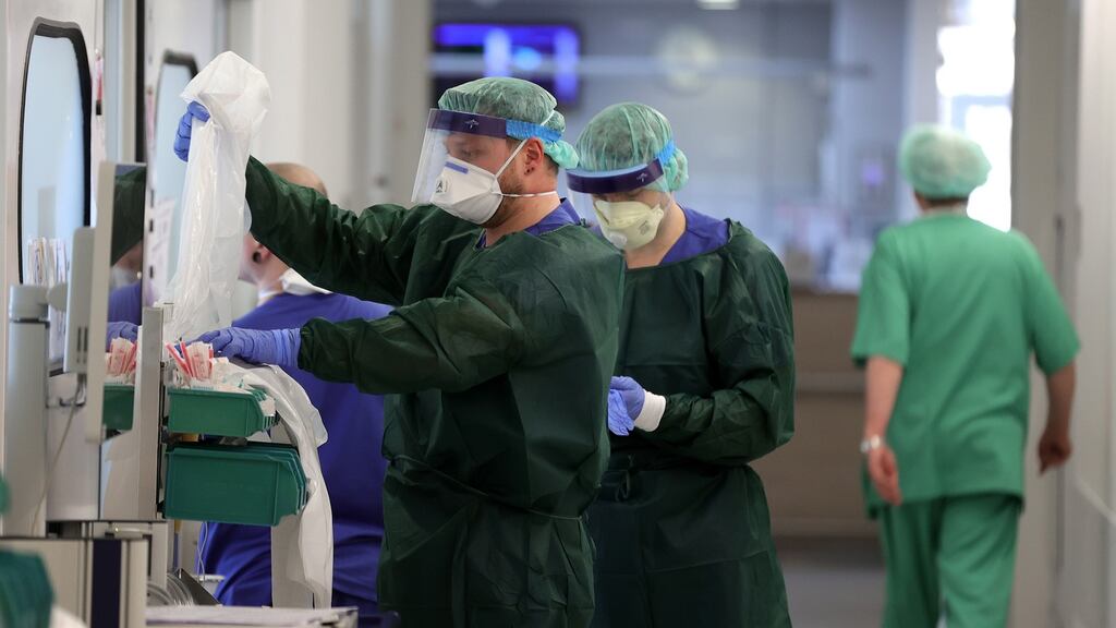 Medical staff put on protective clothing before treating a patient at the intensive care unit of the University Hospital in Essen, Germany. Photograph: Friedemann Vogel/EPA