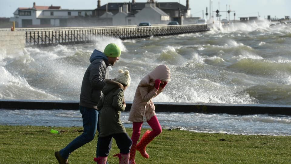 Battling the wind as the high tide inundates the promenade today at Clontarf, Dublin. Photograph: Dara Mac Dónaill/The Irish Times