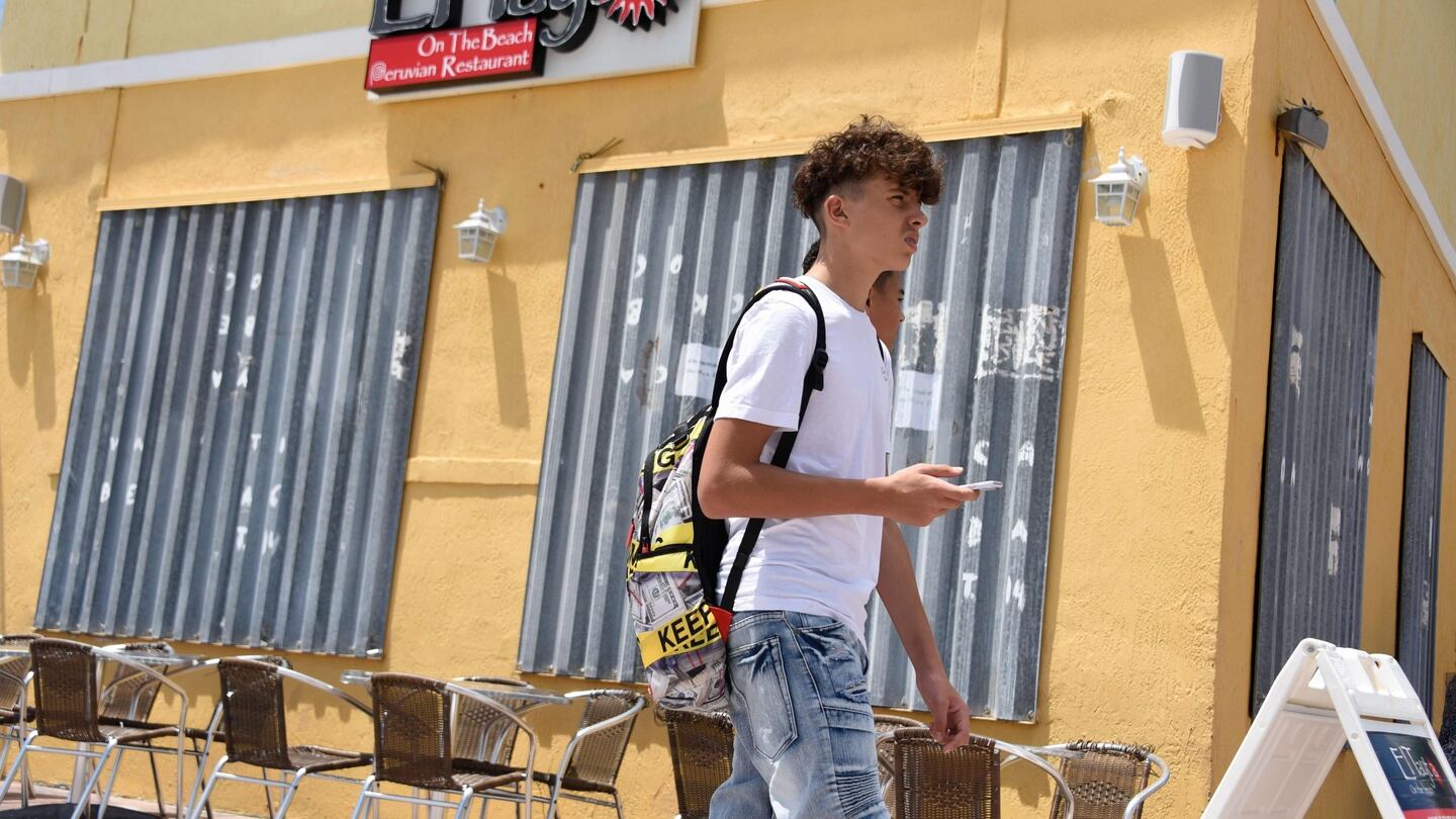 People pass a boarded up business in Hollywood Beach, Florida, as they prepare for Hurricane Dorian. Photograph: Getty Images