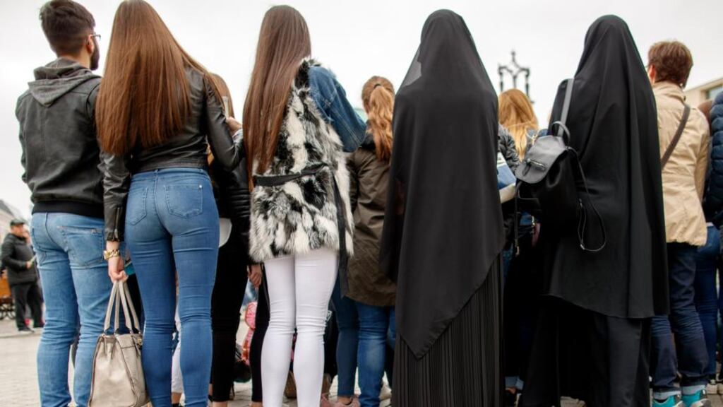 Peope watch a street performer in front of the Brandenburg Gate in Berlin. Photograph: Carsten Koall/EPA