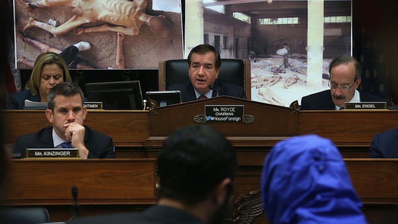 A Syrian Army defector in a blue hooded jacket during a briefing before the US House of Representatives foreign affairs committee in 2014. The defector, a former army photographer, has smuggled out of Syria more than 50,000 photographs that document the torture and death of thousands of Syrians in Bashar al-Assad’s prisons. Photograph: Alex Wong/Getty Images