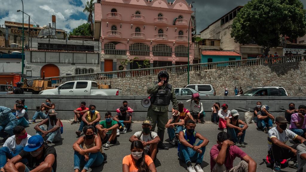 A security officer in Caracas speaks to people detained while he explains the importance of abiding by quarantine measures. Photograph: Adriana Loureiro Fernandez/The New York Times