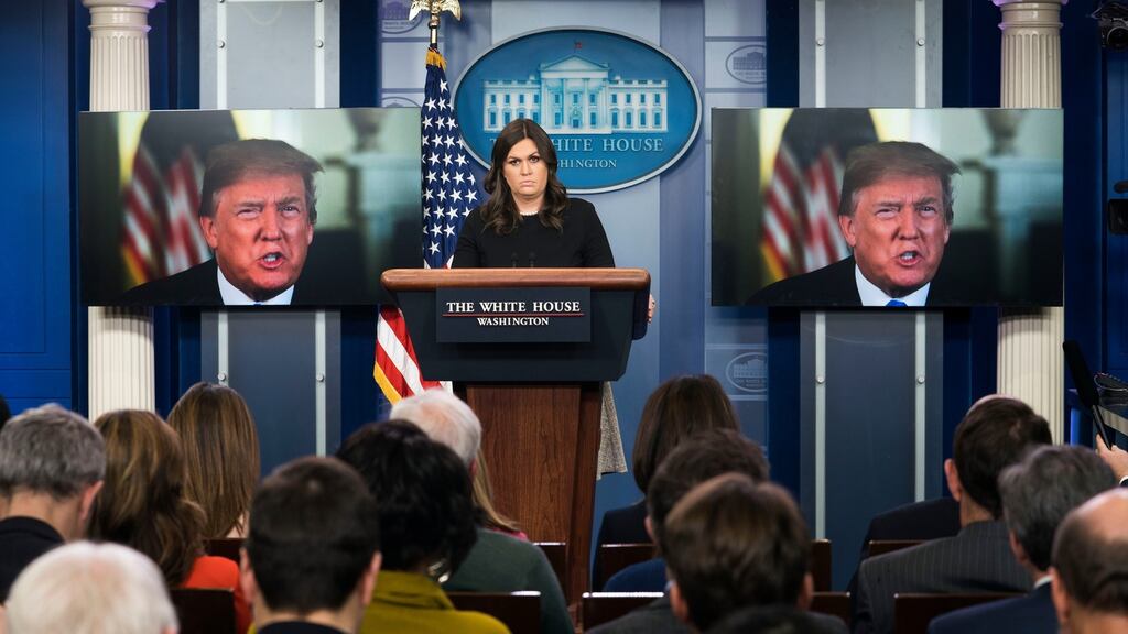 White House press secretary Sarah Huckabee Sanders looks on as US president Donald Trump delivers a statement.