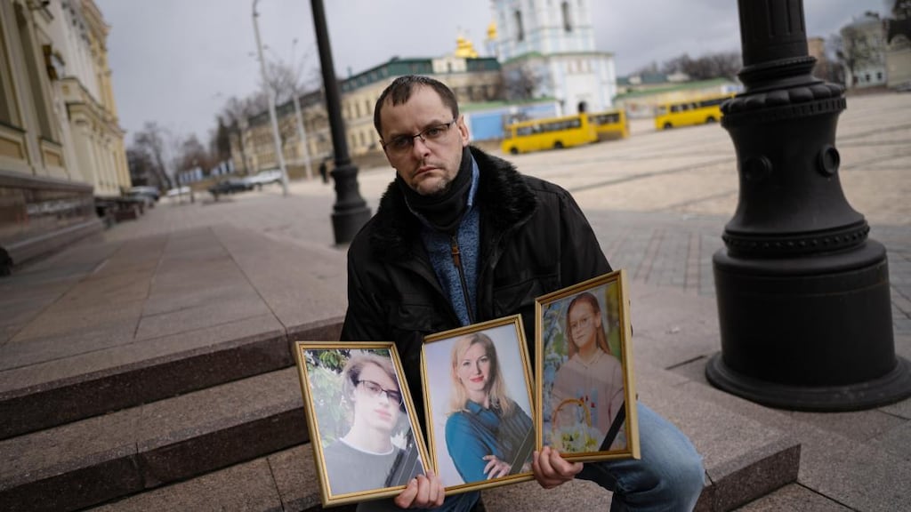 Serhiy Perebyinis holds portraits of his wife, Tetiana, and children Mykyta (18) and Alisa (9), who were killed by Russian mortar fire as they tried to flee fighting outside Kyiv. Photograph: Lynsey Addario/The New York Times