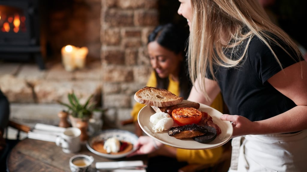 Waitress serving food in a restaurant. Photograph: iStock/ Getty Images